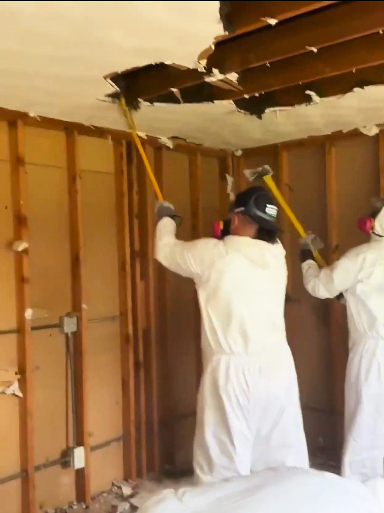 Rapid response water damage mitigation crew performing emergency ceiling demolition and structural drying services after property damage.